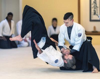 Aikido practitioner executing a dynamic throw technique during advanced seminar training