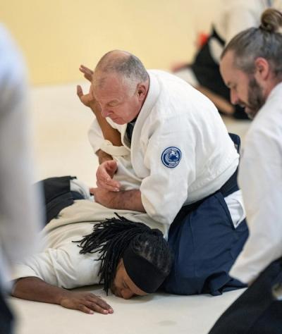 Aikido instructor demonstrating pinning technique on student during class at Tenzan dojo
