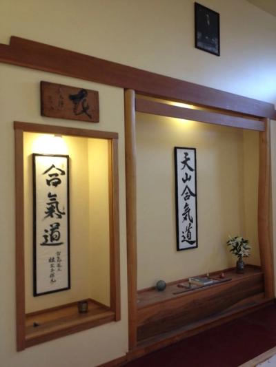 Traditional Japanese shomen altar with aikido calligraphy scrolls and wooden beam framing