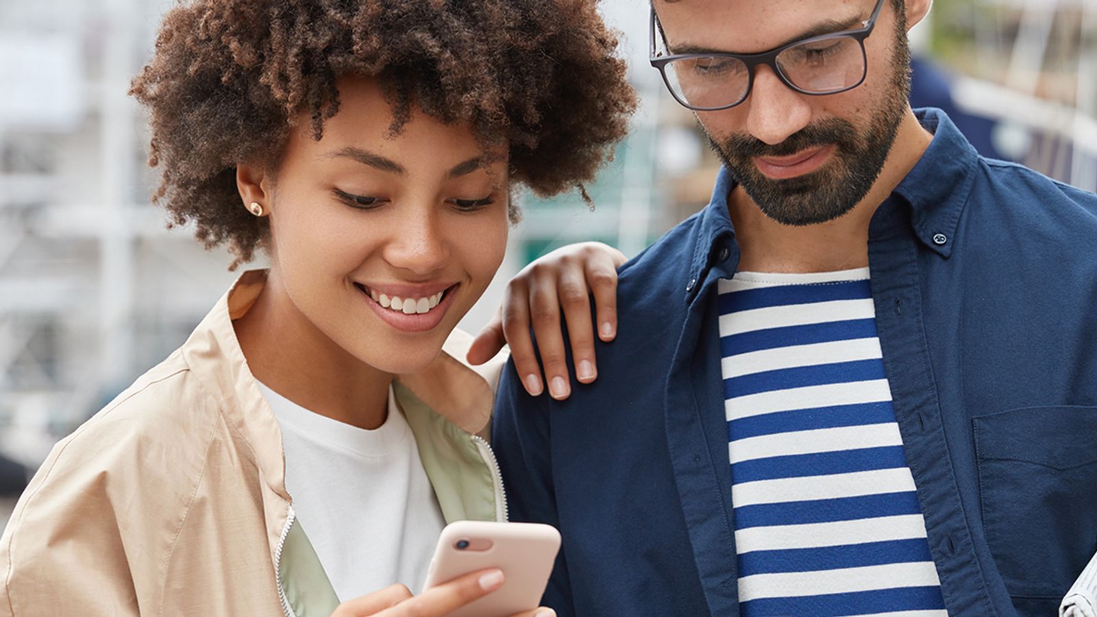 Hombre y mujer viendo opciones en el celular