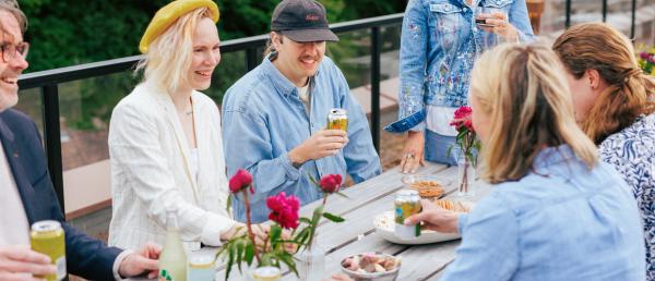 På bildet ser man flere personer som ved et bord og har fest