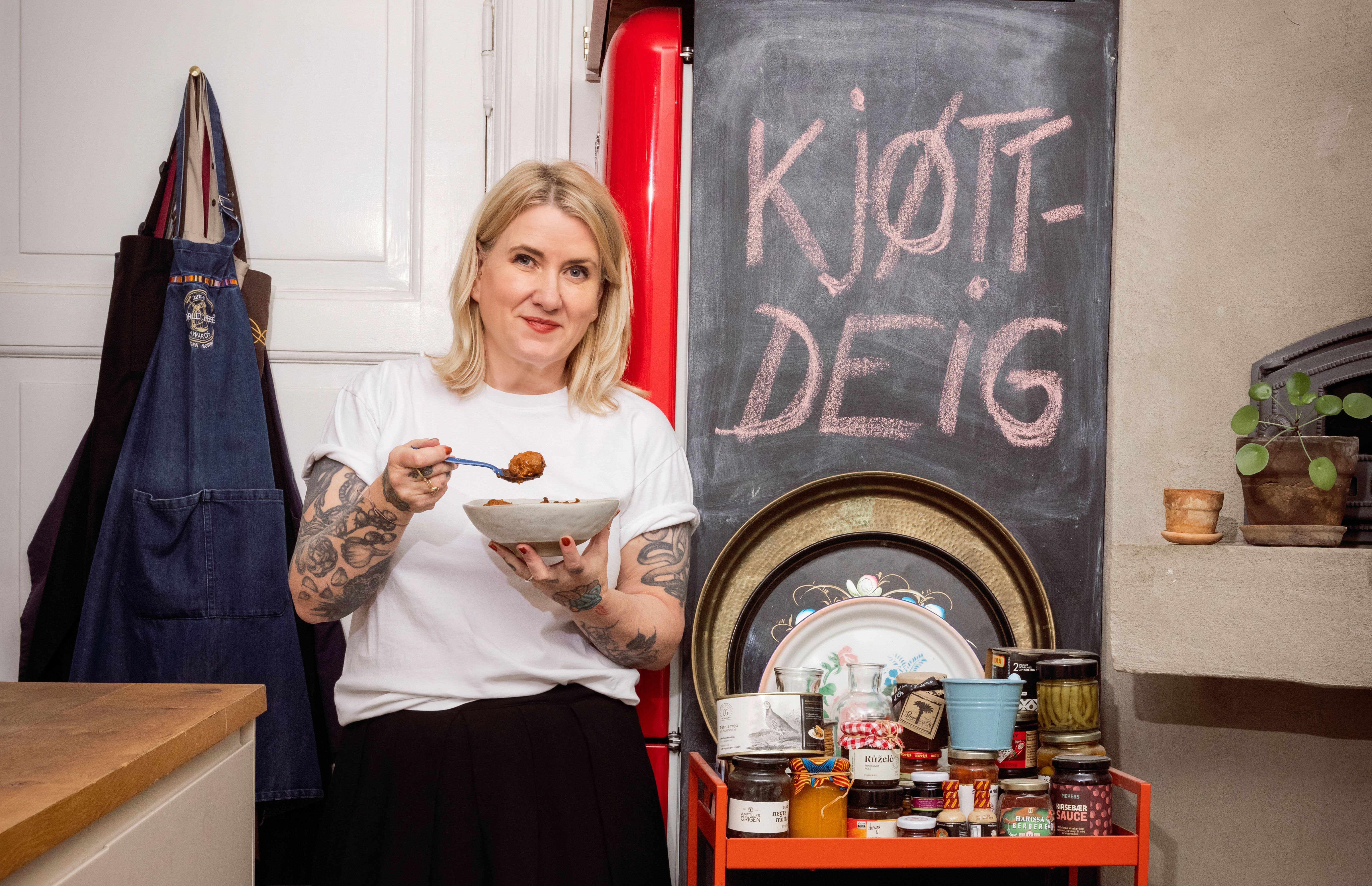 Helle Øder Vallebrokk står på kjøkkenet foran tavle med Kjøttdeig skrevet på