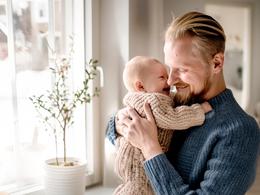 På bilden syns en man hålla i ett litet barn