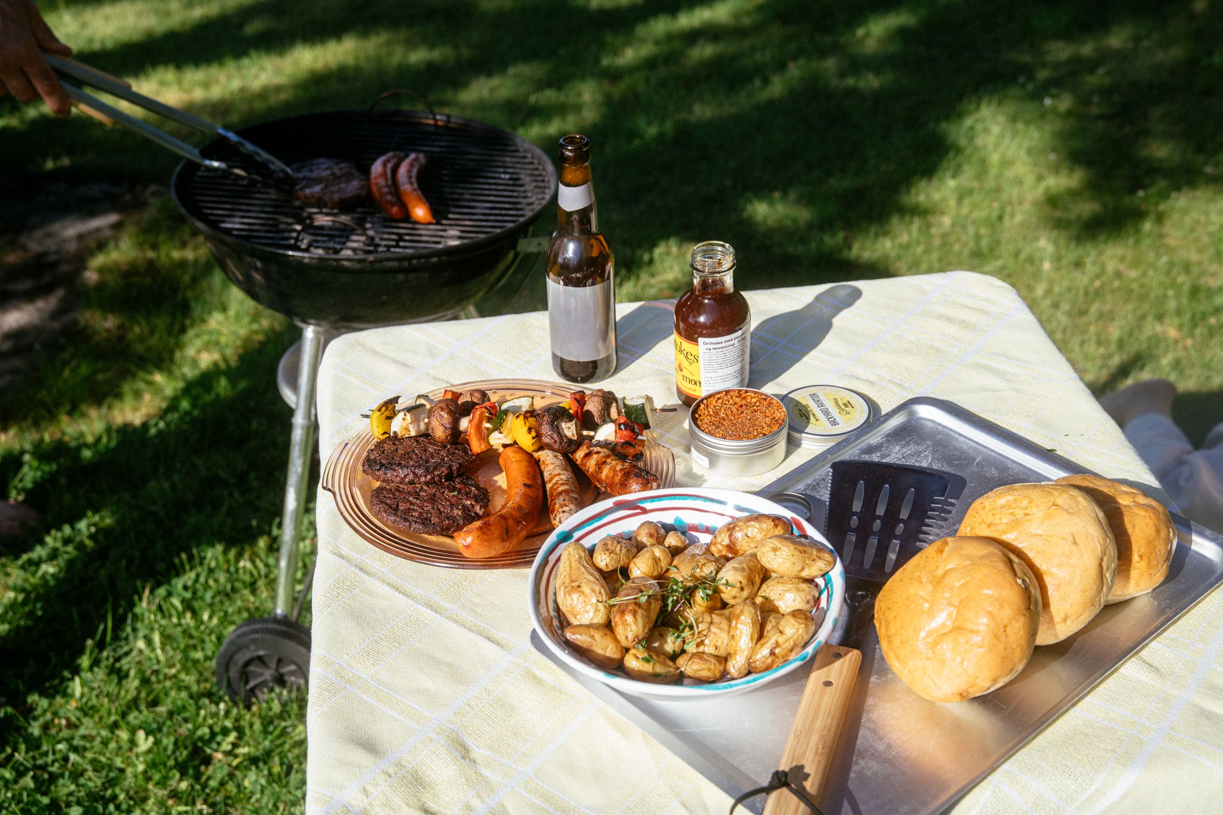 Bildet inneholder et bord dekket for grillmiddag.