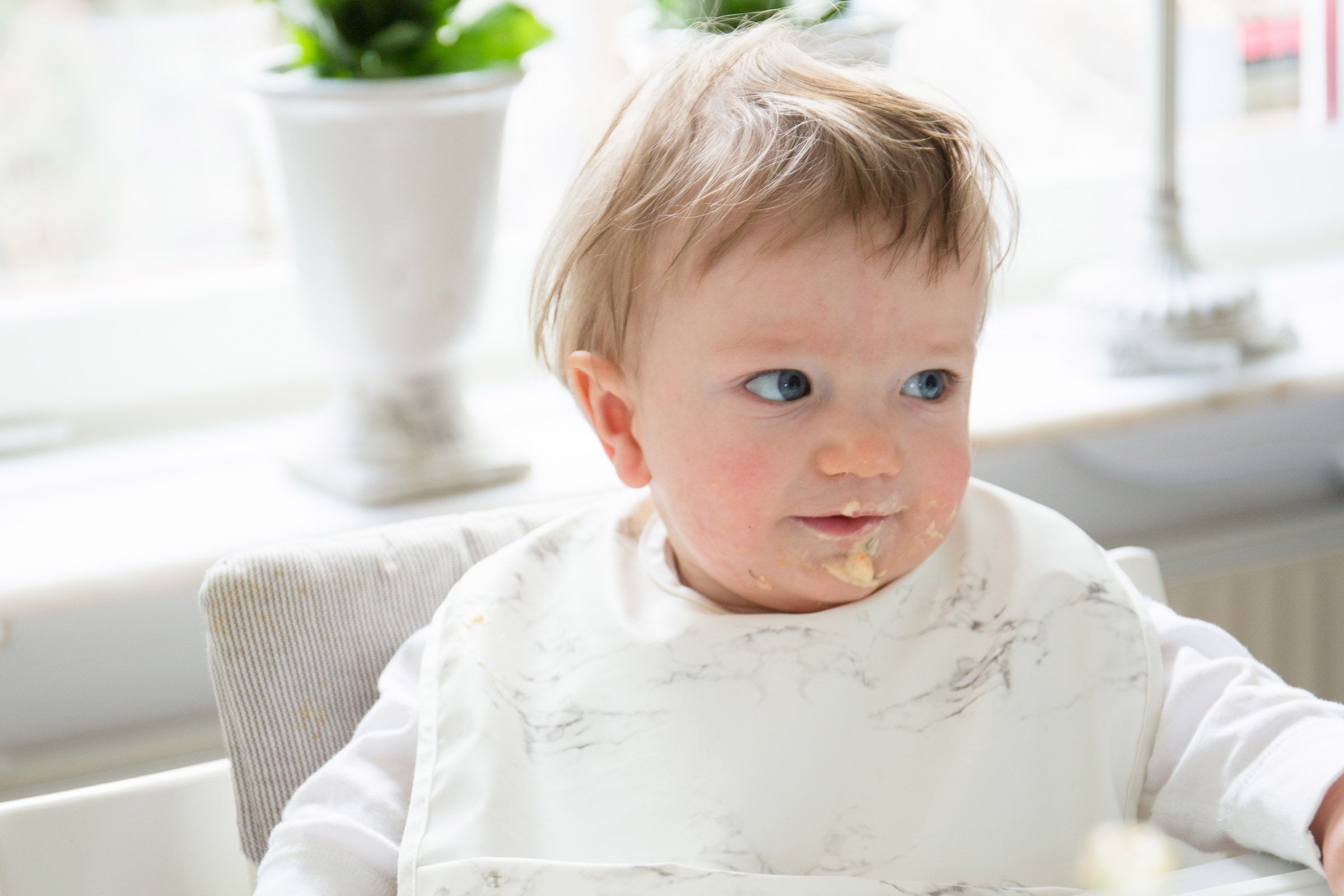 Bebis som äter och har mat runt munnen