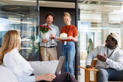 På bildet syns flere personer feire en kollega