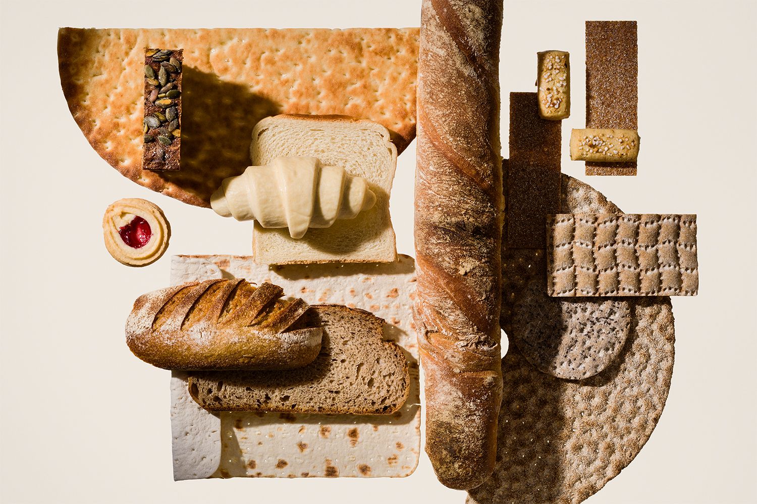På bilden syns flera olika brödsorter mot en ljus beige bakgrund