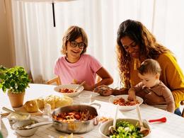 På bildet synes en familie som spiser middag