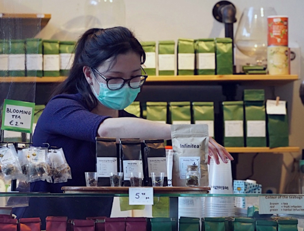 A lady buying tea while wearing a mask