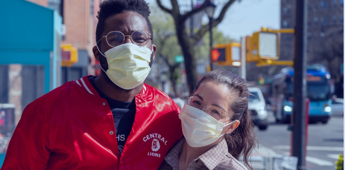Two people on the street wearing masks