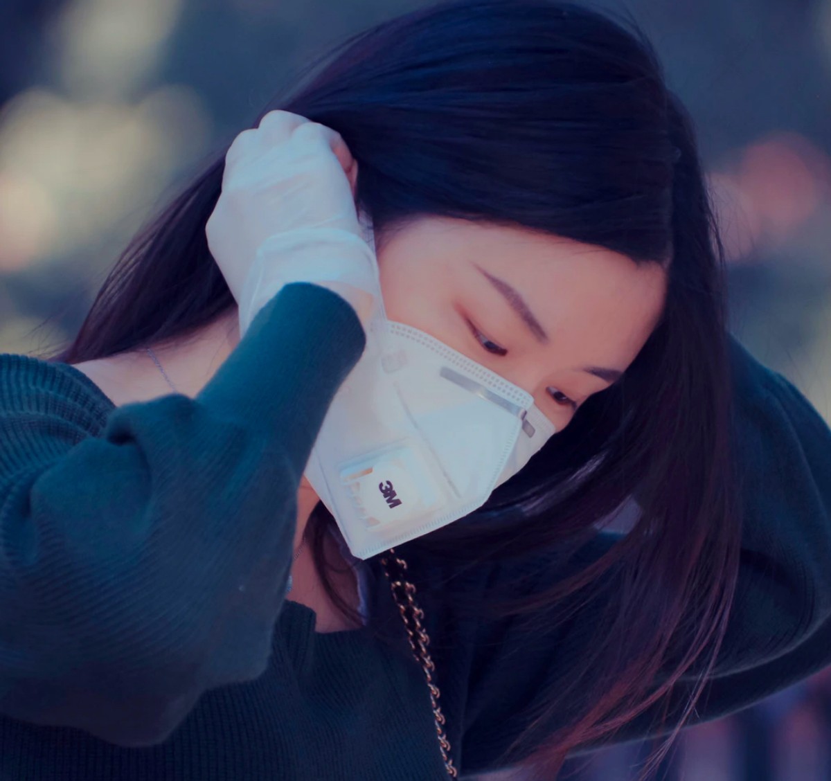 woman on public transportation with a mobile phone wearing a mask