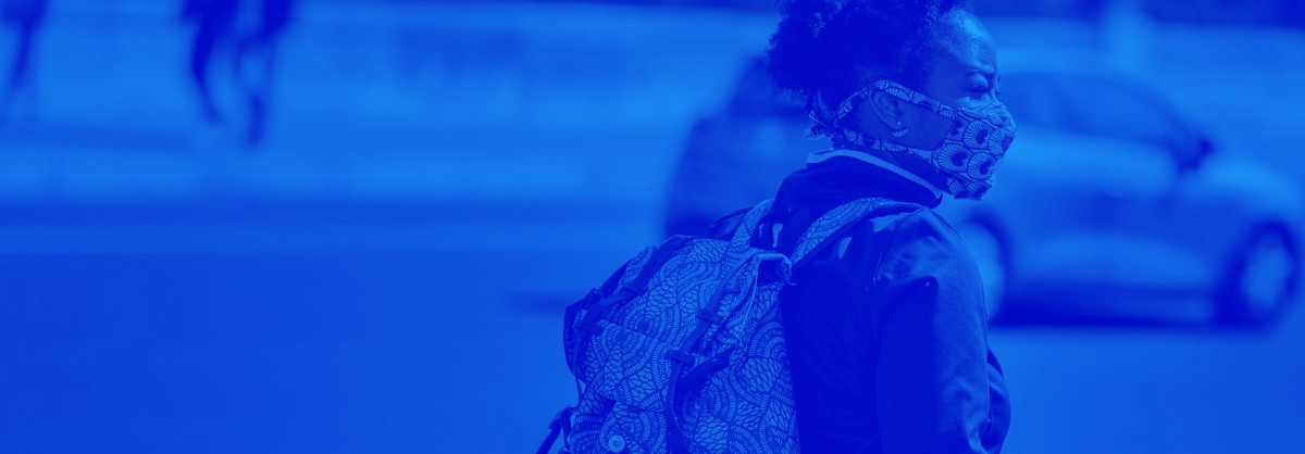 Person looking into a home from outside, wearing a PPE mask