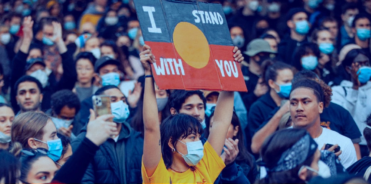 Man walking across a city street wearing a mask