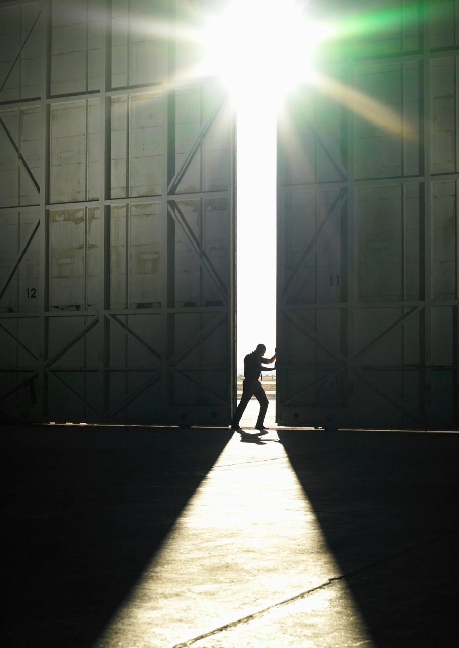 A logistics operator standing in front of warehouse doors