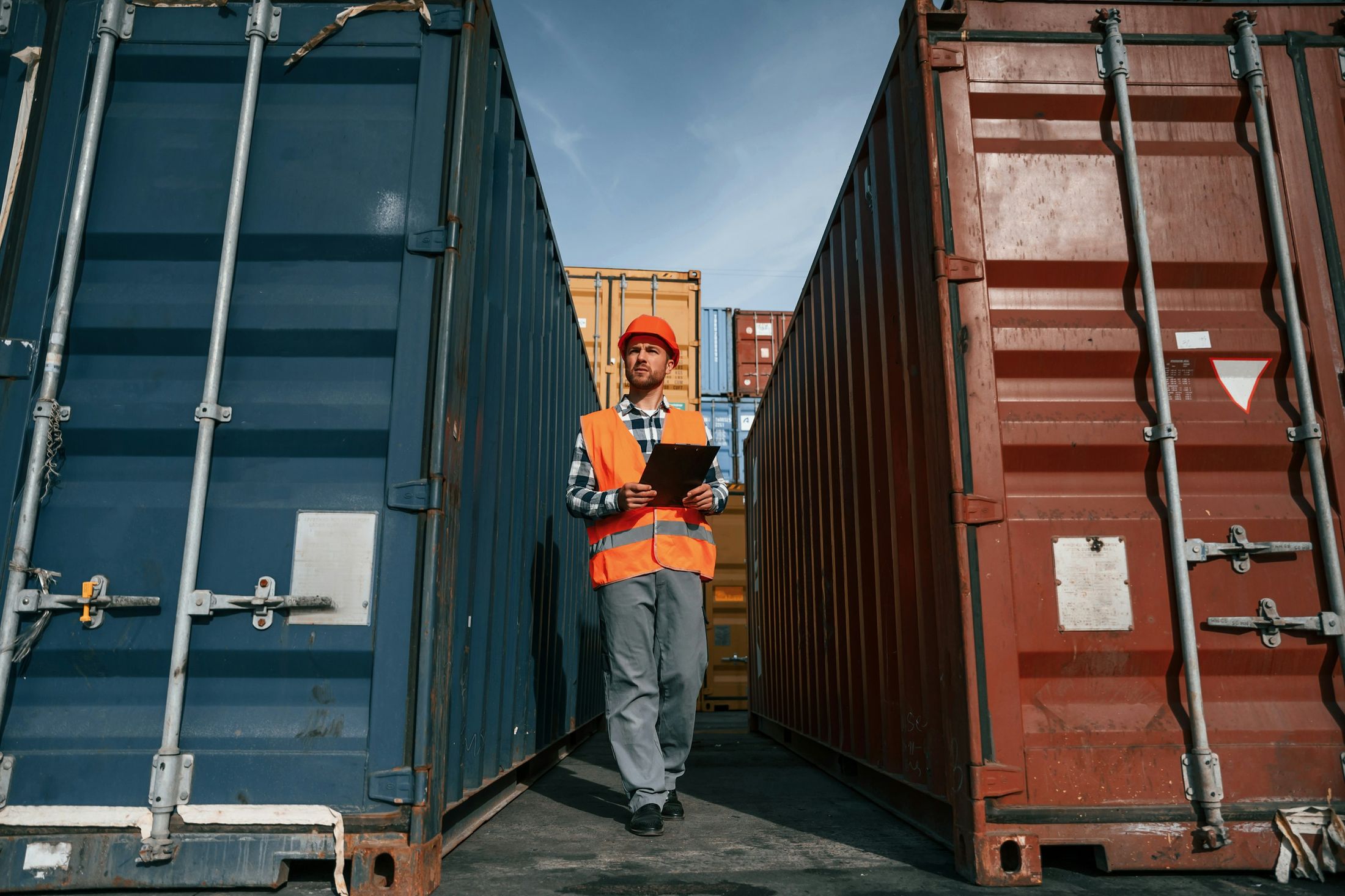 A logistics worker inspecting shipping containers