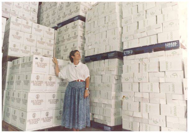 Jane Hunter posing in warehouse with pallets and boxes of wine