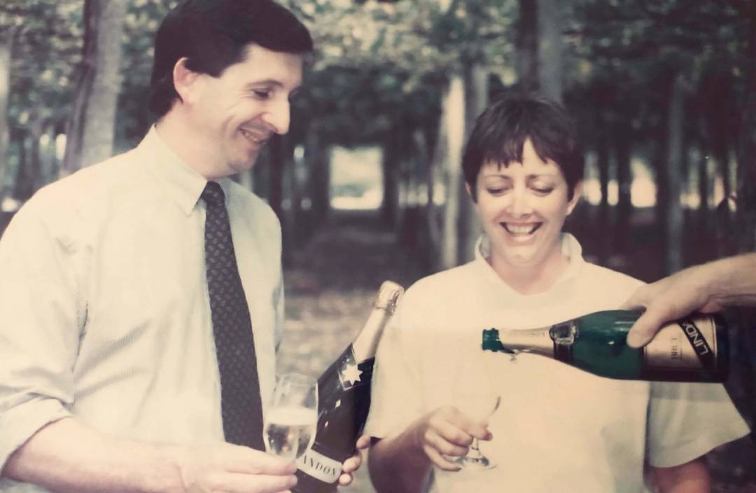 Tony Jordan and Jane Hunter with sparkling wine, under Hunter's trellis, 1990.