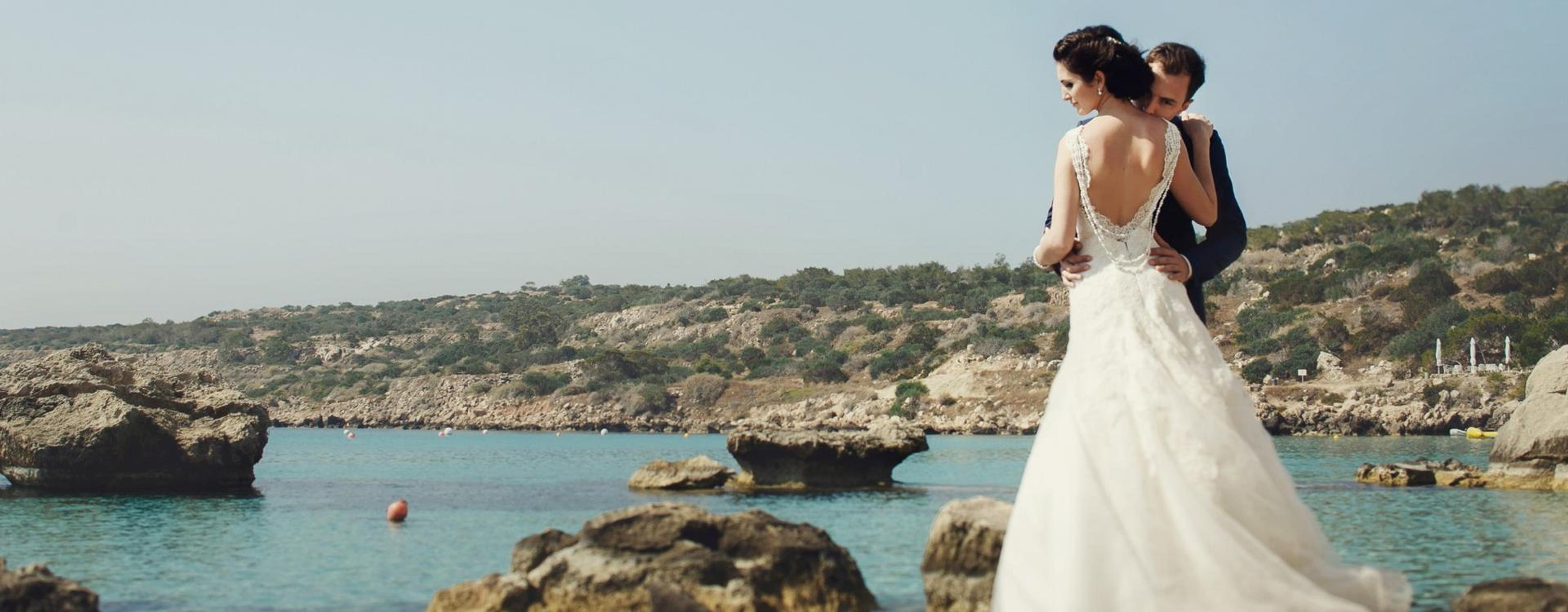 Reportaje de boda con los novios posando junto al agua.