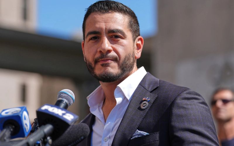 Abdul El-Sayed speaking at a campaign meet-and-greet in front of an "Abdul for US Senate" banner