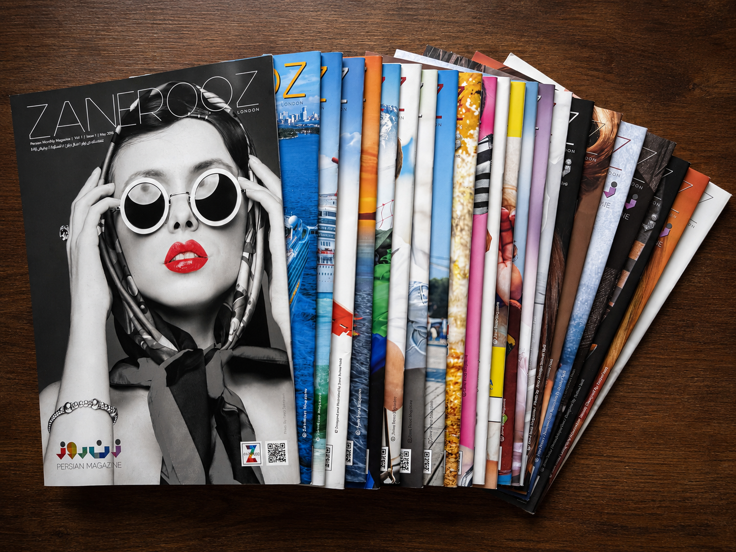 A collection of ZaneRooz magazine issues arranged in a fan, with the first issue featuring a black-and-white portrait with red lips in the foreground.