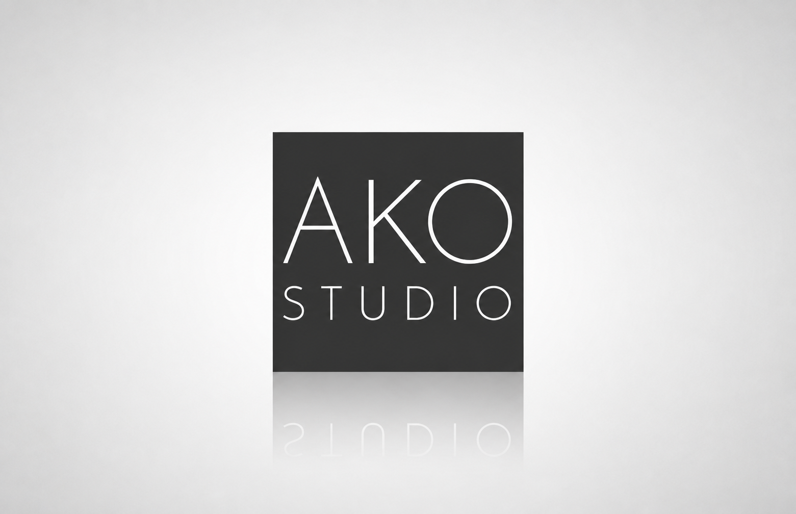 AKO Studio photography logo featuring large, thin uppercase “AKO” lettering above widely spaced “STUDIO” typography, set in white against a dark charcoal rectangular field.