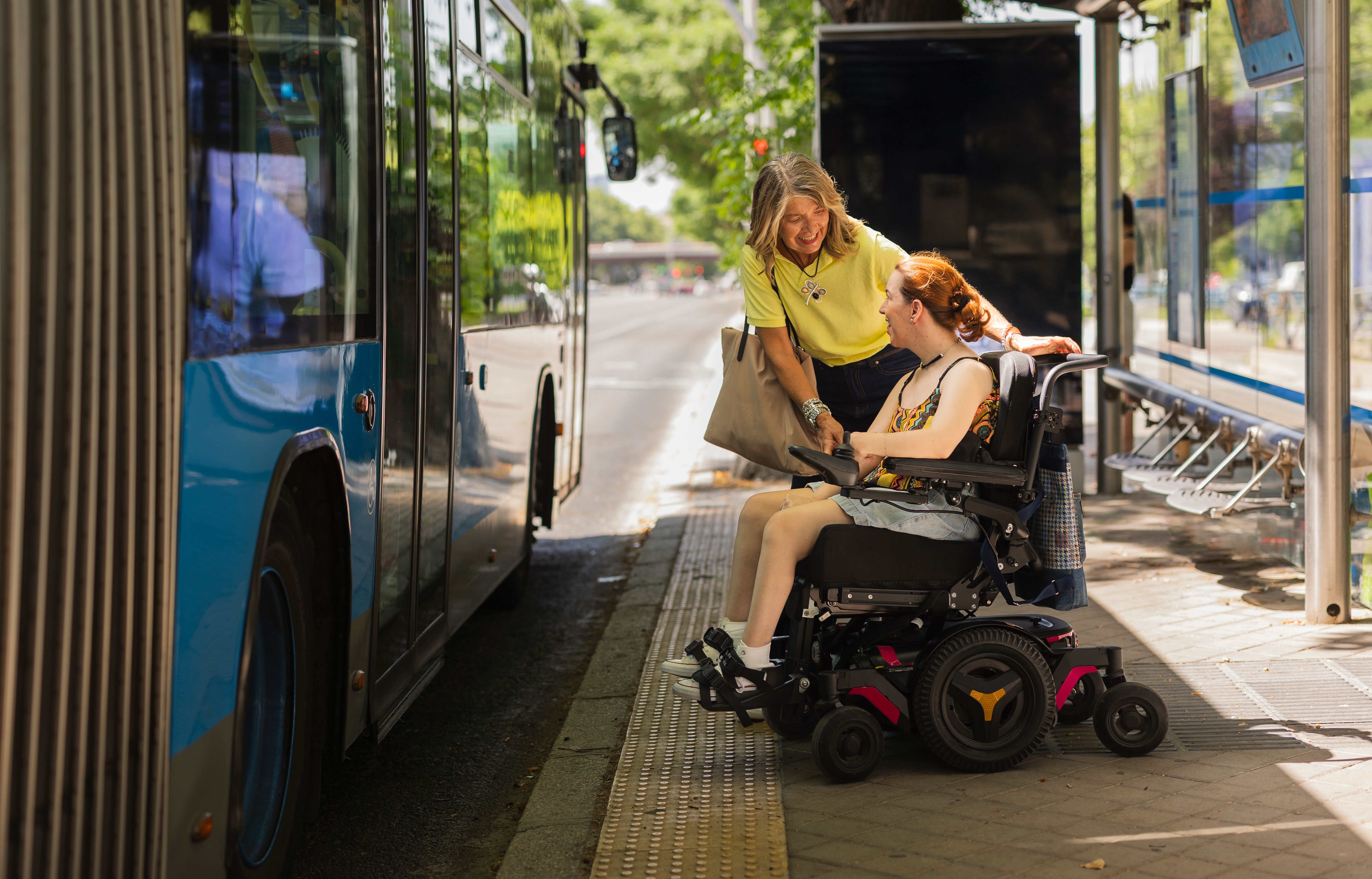 Clinician helping client in wheelchair build capacity to catch public transport