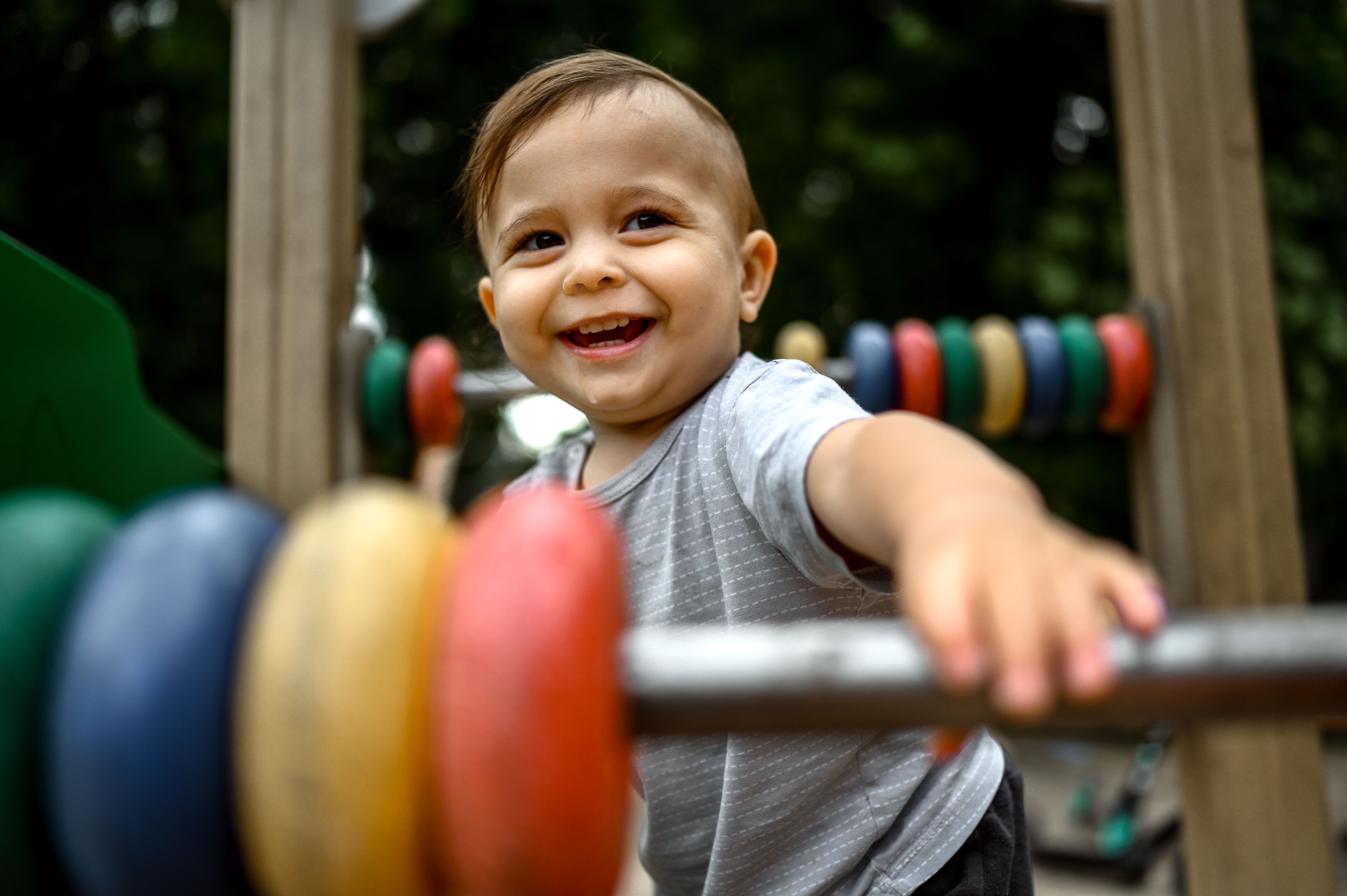 Smiling boy toddler playing in playground. 