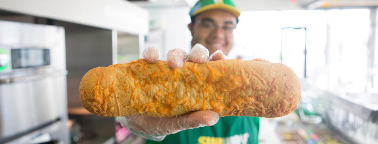 A happy chef holding up freshly baked bread