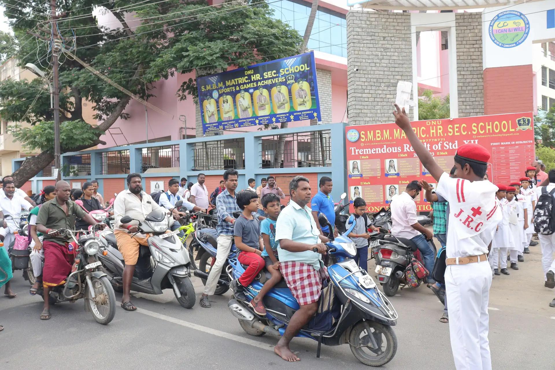 JRC students learning traffic control techniques on a road under supervision.