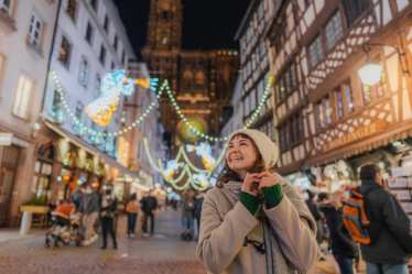 Christmas in Europe - lady smiling surrounded with lights