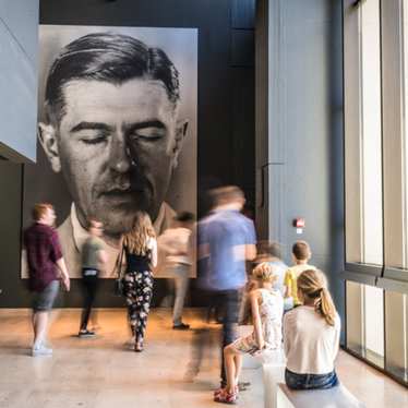 A crowd of people looking at art in the Magritte museum, Brussels.