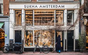 A Dutch bicycle leans against the glass window at Sukha in Amsterdam, a sustainable concept store