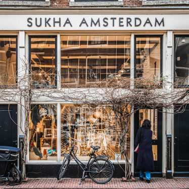 A Dutch bicycle leans against the glass window at Sukha in Amsterdam, a sustainable concept store