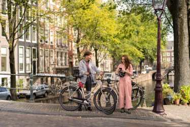 Couple in Amsterdam on the canal with bikes