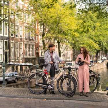 Couple in Amsterdam on the canal with bikes