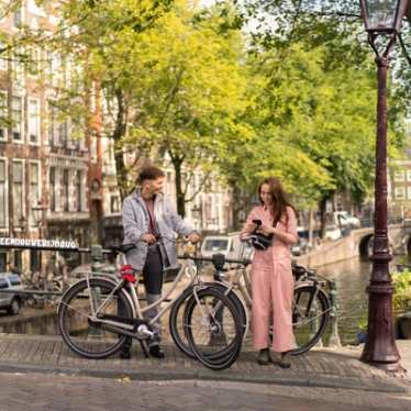 Couple in Amsterdam on the canal with bikes