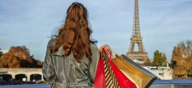 Lady with shopping bags looking at the Eiffel Tower in Paris