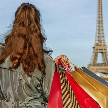 Lady with shopping bags looking at the Eiffel Tower in Paris