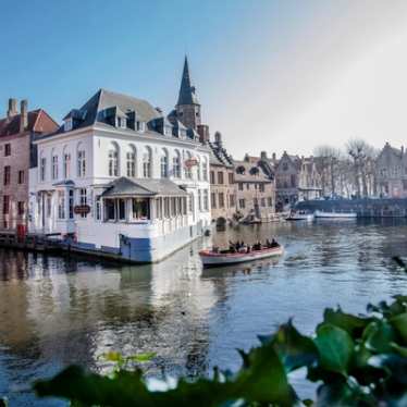 Boat on a Bruges canal on a sunny day.