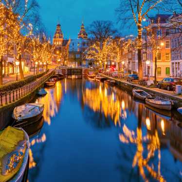Amsterdam Netherlands canals with christmas lights during December, canal historical centre of Amsterdam at night