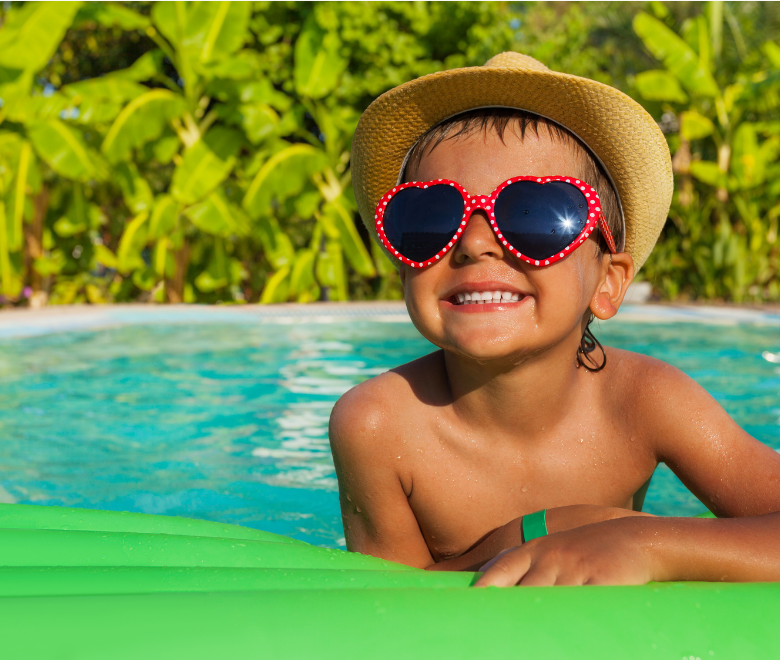 A child in a swimingpool wearing sunglasses 