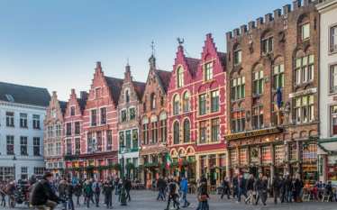 Colourful step-gabled houses line one side of Bruges’s Markt
