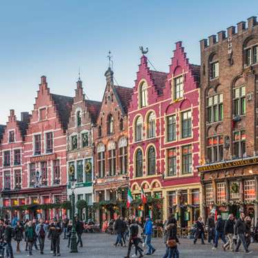 Colourful step-gabled houses line one side of Bruges’s Markt