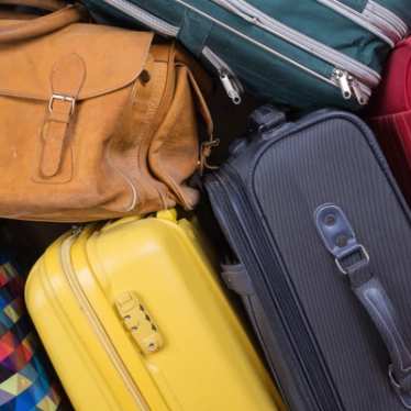 A pile of suitcases in a variety of colours.