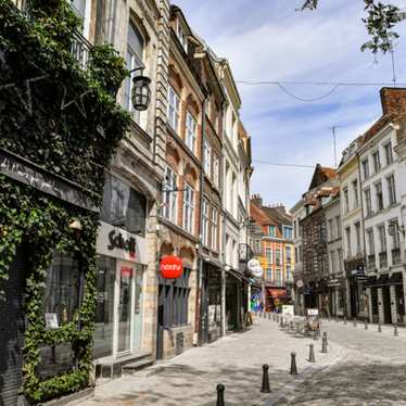 A quiet street of shops on a sunny day in Lille.