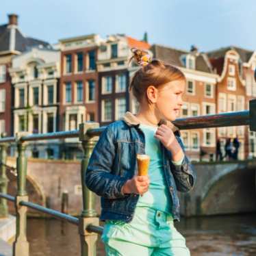 Kids in Amsterdam eating ice cream looking out over canal