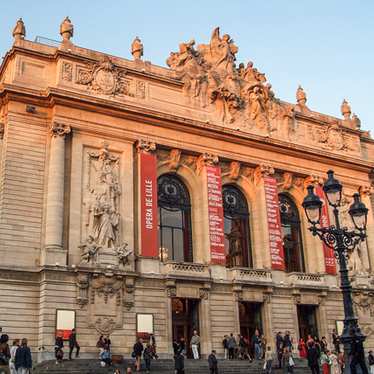 People gathered outside Opera de Lille on a sunny day.