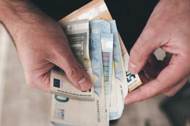 Man holding euro bills, counting money - prohibited items - money - customs