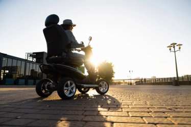 Woman riding a four wheel mobility electric scooter - accessible travel - accessibility