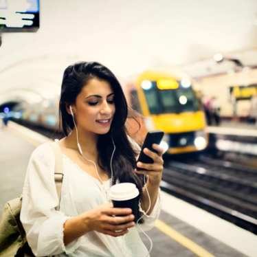 Young woman using a phone at train station